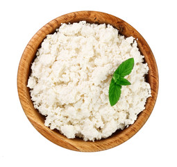 Cottage cheese in a wooden bowl isolated on a white background. Top view. Flat lay