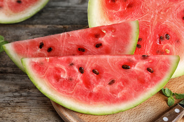 Wooden board with juicy watermelon slices on table