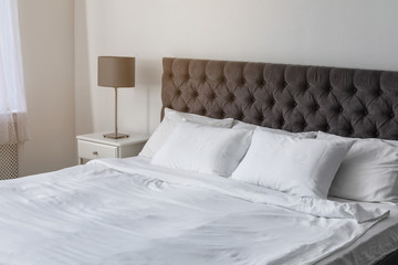Soft white pillows on comfortable bed indoors
