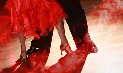 Man and woman dancing Salsa on dark