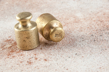 Antique bronze weights for scales on concrete background.