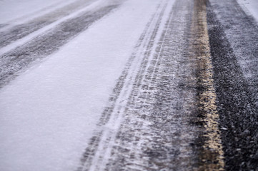 Tracks in snow on winter asphalt road