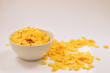 Corn flakes falling to the white bowl. Motion. Copyspace.
