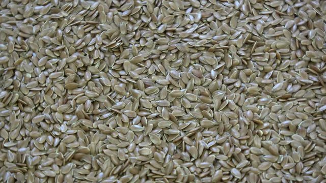 Rotating flax seeds background and texture