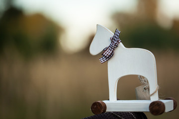 White wooden horse toy with wheels