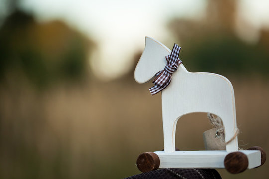 White wooden horse toy with wheels