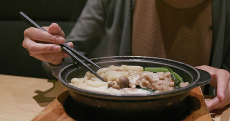 Woman eating udon in Japanese restaurant
