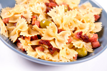 Farfalle pasta with sun dried tomato, ham and olives