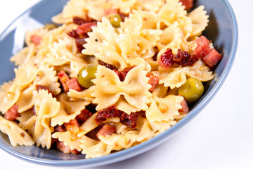 Farfalle pasta with sun dried tomato, ham and olives