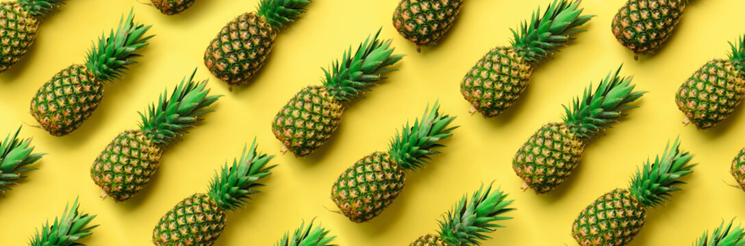 Chaotic pineapple pattern for minimal style. Top View. Pop art design, creative concept. Copy Space. Banner. Fresh pineapples on yellow background.