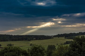The landscape. Beam of sunlight. View from the rock hill to landscape. Amazing and dramatic clouds and sky.