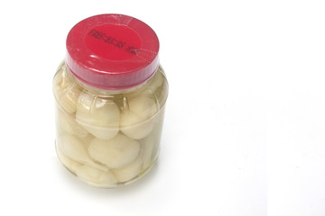 Pickled garlic in a plastic bottle packing empty space on a white backdrop. The date of manufacture and expiration.