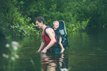 A man with a child crosses the river ford.