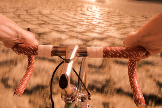 H&auml;nde am Radlenker vom Rennrad und Str&szlig;e mit Kopfsteinpflaster