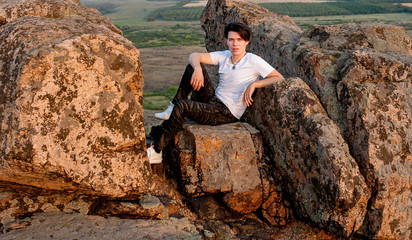 Naklejka na ściany i meble tourist and model at the top of the mountain enjoying the sunset over the tropical valley, posing in front of the camera 