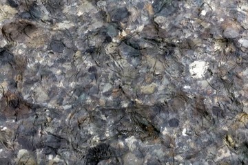 Water surface of a clear mountain river with stones.