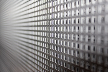 Abstract perforated metal plate steel sheets with grid pattern as backdrop for industrial looks