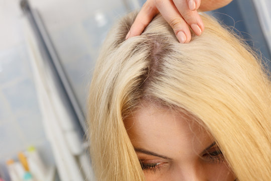 Woman showing blonde hair roots