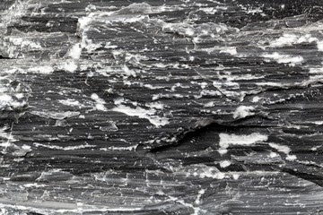 The surface of a geological fault in a dark marble from the Austrian Alps.