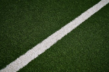 Artificial green grass football / soccer field / pitch & white stripe - close up