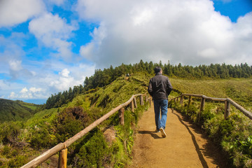 Person taking a hike on lake / lagoon of the seven cities (lagoa das sete cidades) on the island of Sao Miguel Azores, Portugal