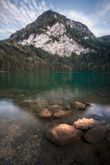 Gleinkersee Oberösterreich - Steine im stillen Wasser mit Berg im Hintergrund