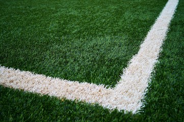 Artificial green grass football / soccer field / pitch & white stripe - close up