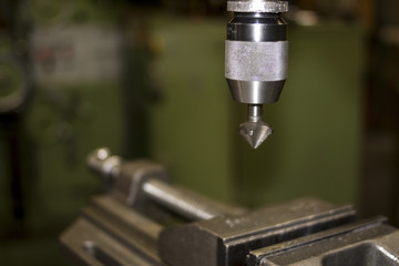 Industrial workshop with classic green drill machine for metal craft work with exchangeable...