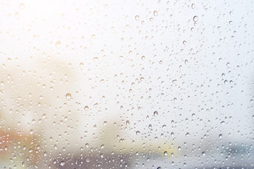 rain drops on glass in cloudy weather with blurred background