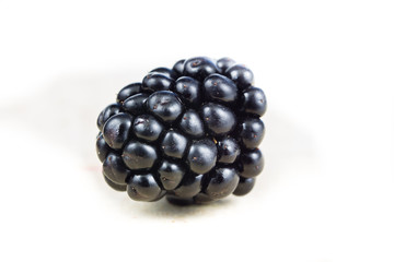 Tasty and ripe blackberries on a white kitchen table. Delicious forest fruits for desserts.