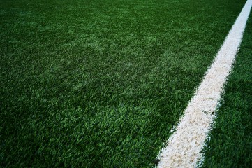 Artificial green grass football / soccer field / pitch & white stripe - close up