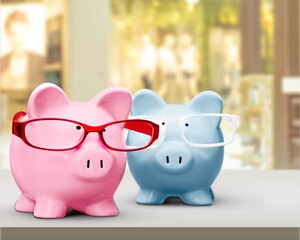 Piggy bank in glasses on background