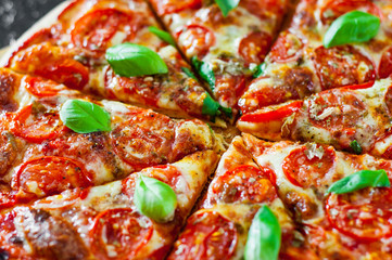 sliced Pizza with Mozzarella cheese, Tomatoes, pepper, Spices and Fresh Basil. Italian pizza. Pizza Margherita or Margarita