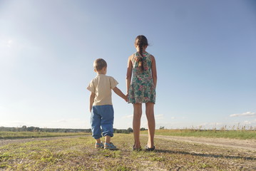 Fototapeta premium small boy and girl standing on a rural road