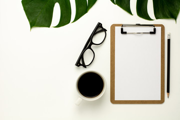 clipboard and white paper on white office desk background. Flat lay design.