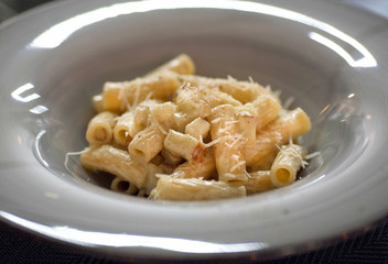 Close-up on plate with cheese pasta and olive oil, in traditional italian restaurant or cafe