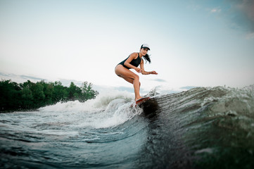 Young attractive woman riding on the orange surf