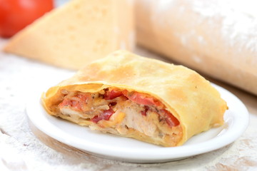 strudel with ham and cheese on a wooden board with flour
