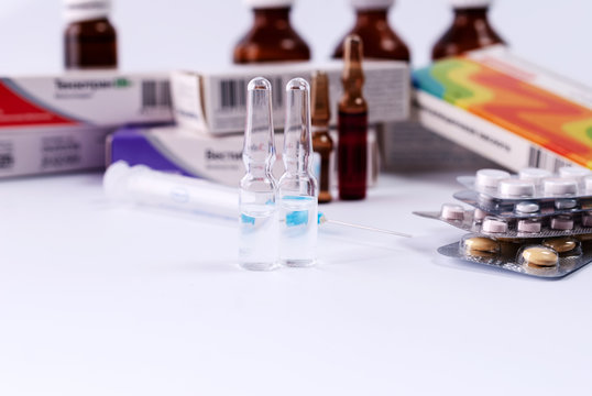 Ampoules on the background of packs with medicines. Medical concept