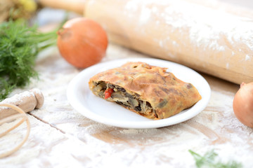 strudel with meat on a wooden board with flour