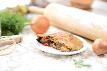 strudel with meat on a wooden board with flour