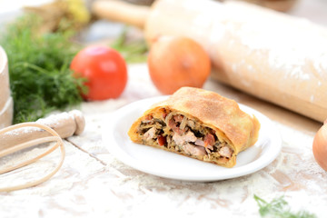 strudel with meat on a wooden board with flour