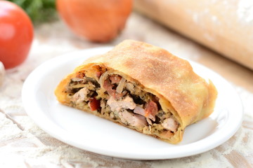strudel with meat on a wooden board with flour