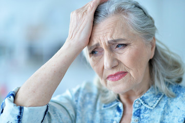 portrait of senior woman with headache