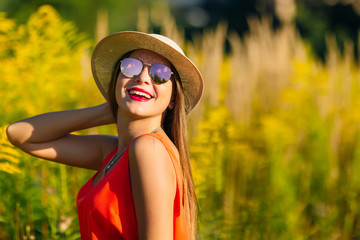 elegant girl in sunglasses and a stylish hat cute smiles and hol