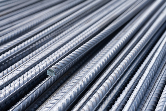 Stack of heavy metal reinforcement bars with periodic profile texture. Close up steel construction armature. Abstract industrial background concept. Copy space.