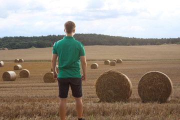 Mann steht vor einem Kornfeld