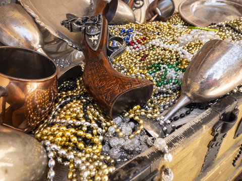 Close Up of Pirates Treasure chest of Guns, Jewelery and Cups