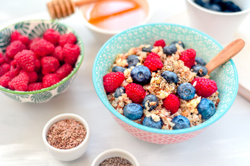 High protein healthy breakfast, buckwheat porridge with blueberries, raspberries, flax seeds and honey Closeup view, selective focus