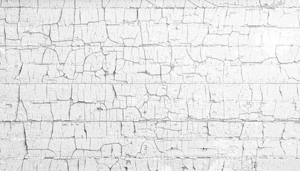 Black and white gray textured wall boards with chipped and cracked paint chips falling off. Antique old aged painted finish.